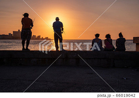 キューバ　ハバナ　モロ要塞の前で釣りをする人　夕陽の海岸 66019042