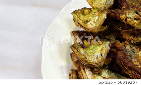 Close up of scrimp scad fish, fried and served on a plate, with marble background. Close up of scrimp scad fish, fried and served on a plate, with marble background. 66019207