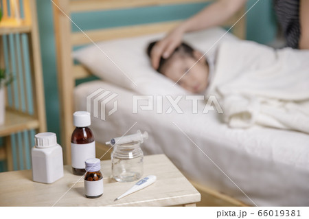 The little girl was sick and sleep on bed. Mother takes care and putting blanket on her daughter 66019381