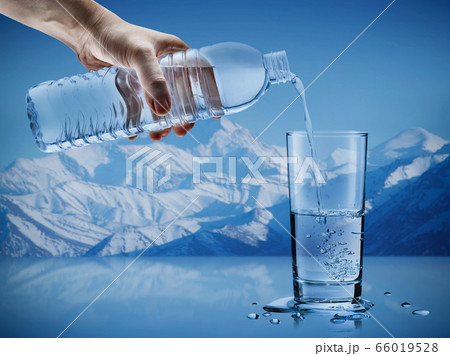 Hand pouring mineral water from bottle into a glass with water drops in the iceberg background, Healthcare and beauty hydration concept Hand pouring mineral water from bottle into a glass with water drops in the iceberg background, Healthcare and beauty hydration concept 66019528