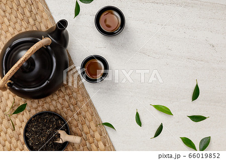 Tea cup with teapot, organic green tea leaves and dried herbs on the white stone empty space creative flat lay, Organic product from the nature for healthy with traditional style Tea cup with teapot, organic green tea leaves and dried herbs on the white stone empty space creative flat lay, Organic product from the nature for healthy with traditional style 66019852