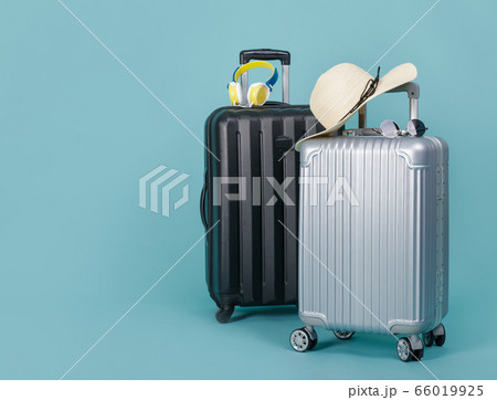 Two Travel Baggage with hat and sunglasses isolated on blue background with copy space, Travel concept background Two Travel Baggage with hat and sunglasses isolated on blue background with copy space, Travel concept background 66019925