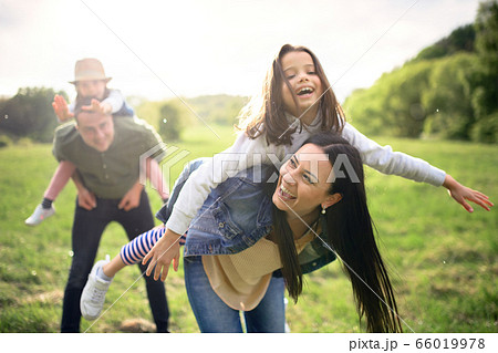 Happy family with two small daughters having fun outdoors in spring nature. 66019978