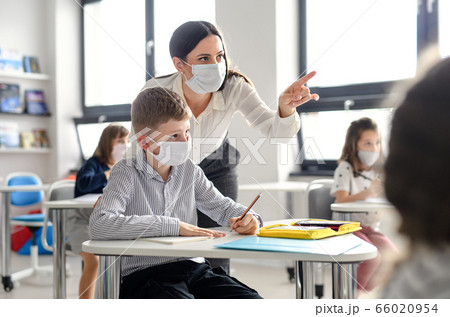Teacher and children with face mask back at school after covid-19 quarantine and lockdown. 66020954
