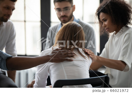Rear view diverse people supporting upset woman at therapy session 66021972