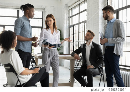 Confident businesswoman mentor leading briefing, teaching diverse employees Confident businesswoman mentor leading briefing, teaching diverse employees 66022064