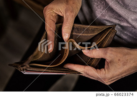 Empty wallet in the hands of an elderly man. 66023374