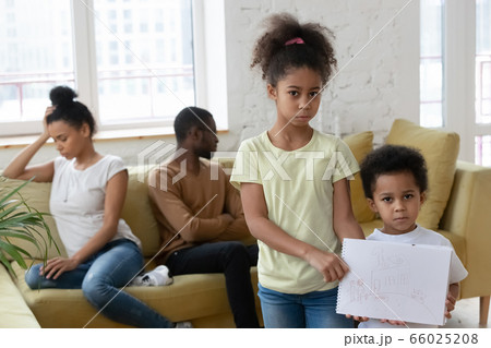 Unhappy little African children holding drawing suffers from parents divorce Unhappy little African children holding drawing suffers from parents divorce 66025208