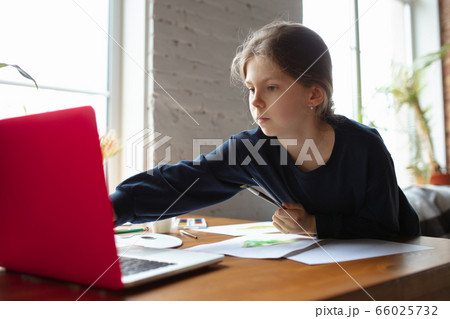 Girl drawing with paints and pencils at home, watching teacher's tutorial on laptop. Digitalization, remote education Girl drawing with paints and pencils at home, watching teacher's tutorial on laptop. Digitalization, remote education 66025732