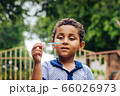 Smiling boy playing soap bubble 66026973