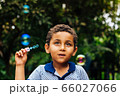 Smiling boy playing soap bubble 66027066