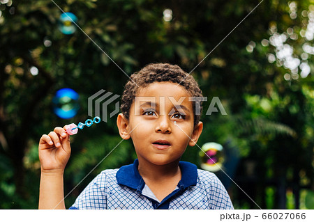 Smiling boy playing soap bubble 66027066