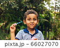 Smiling boy playing soap bubble 66027070