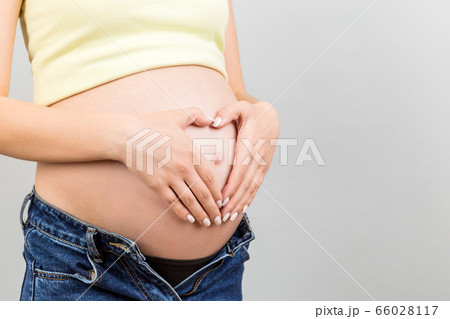 Close up of pregnant woman in unzipped jeans Close up of pregnant woman in unzipped jeans 66028117