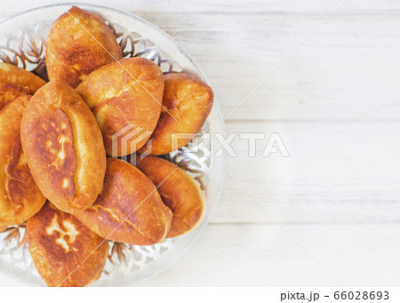 Piroshki - russian baked puff pastry with cabbage fillings. Traditional russian cabbage stuffed baked pastry. lean pies with cabbage. Beautiful homemade cakes with cabbage in metal dishes on white 66028693