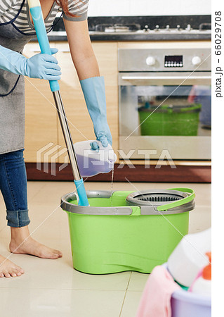 Woman pouring multi-purpose floor cleaner solution 66029708