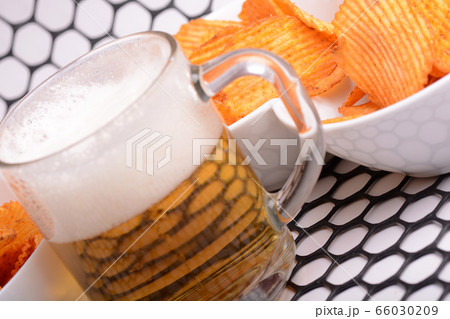 Glass of light beer and potato chips on a abstract 66030209