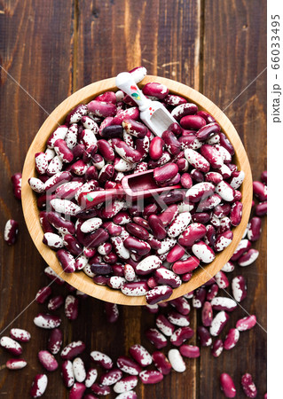 Violet with dots beans in wooden plate with two spoons. Swallow beans.  66033495