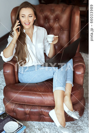 Bisinesswoman working at home office. Young women calling on mobile phe and working on laptop from home 66033989