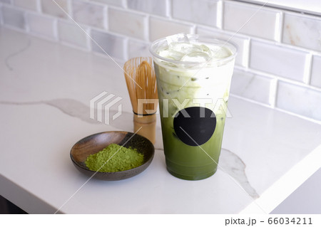 Green tea latte with ice in plastic cup and straw on wooden background.  Homemade Iced Matcha Latte Tea with Milk take away Stock Photo by  ©galitskaya 242393070