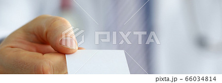 Male physician hand holding and giving white blank calling card 66034814