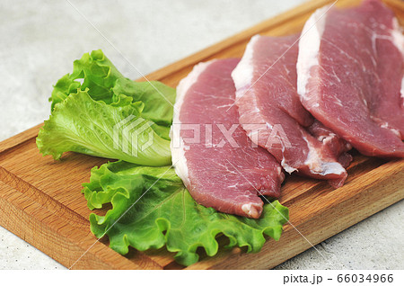 raw pork steak - pork neck - with lettuce leaves raw pork steak - pork neck - with lettuce leaves 66034966