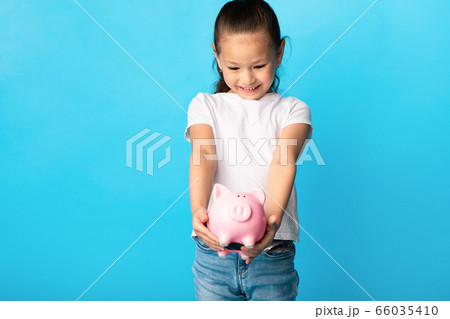 Little girl with piggy bank, studio shot, free space Little girl with piggy bank, studio shot, free space 66035410