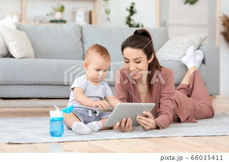 Happy young mother and adorable baby boy using digital tablet at home Happy young mother and adorable baby boy using digital tablet at home 66035411