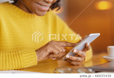 Cropped of black lady using mobile phone 66035439