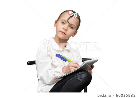 schoolgirl writes in a notebook 66035935