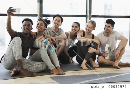 Happy multicultural friends taking selfie on smartphone after fitness training Happy multicultural friends taking selfie on smartphone after fitness training 66035975