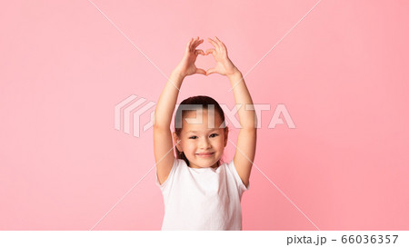 Asian girl showing heart gesture with fingers 66036357