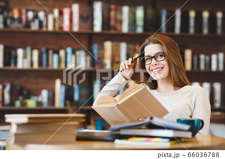 Young smiling woman studying with many books at home 66036788