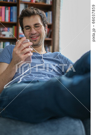Young man communicating with his friend on a smart Young man communicating with his friend on a smart 66037859