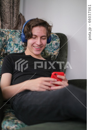 Teenager is communicating with his friends on a 66037861
