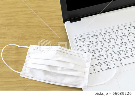 テーブル上の白いマスクとノートパソコン 66039226