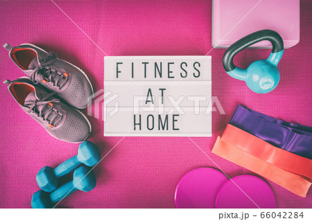 Fitness at home sign with pink yoga mat, running shoes, kettlebell weight and dumbells resistance bands and sliders for pilates online class. Exercise indoors for women 66042284