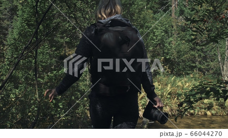 Traveler photographing scenic view in forest river. Wood bridge fallen tree. One caucasian woman shooting nice magic look. Girl take photo on camera. 66044270