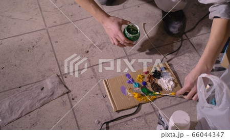 Artist designer draws an eagle on the wall. Craftsman decorator paints picture with acrylic oil color. Painter painter dressed in paint coat. Indoor. 66044347