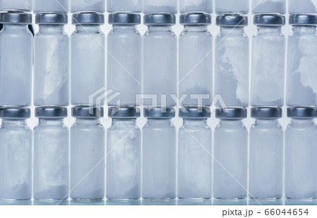 Glass medical ampoule vial for injection. Medicine is dry white drug penicillin powder or liquid with of aqueous solution in ampulla. Close up. 66044654