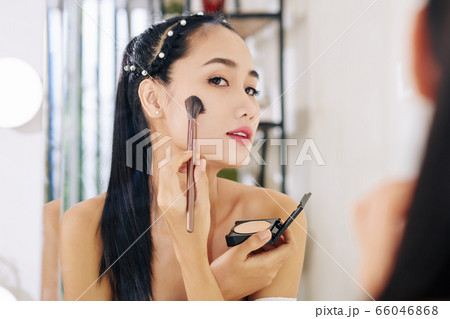 Woman applying pressed powder 66046868