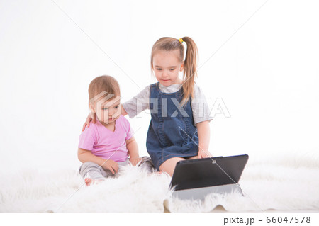 the kids are watching cartoons on the tablet. Home schooling for girls during quarantine 66047578