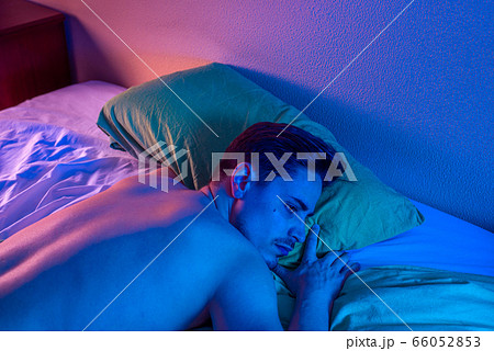 young man with insomnia trying to sleep at night 66052853