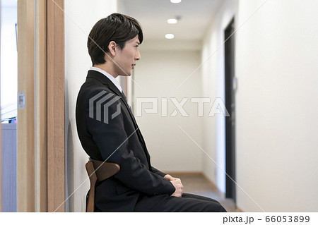 廊下で面接の順番を待つ若い男性　就活・受験イメージ 66053899