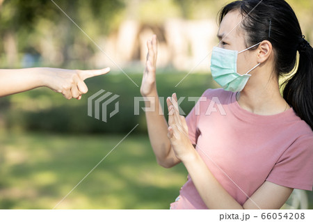Sad asian girl student in hygienic mask during the pandemic of Coronavirus or Covid-19,hand pointing finger to scared child girl,bullying victim and hate,anti racism,stop xenophobia,bullied by society 66054208