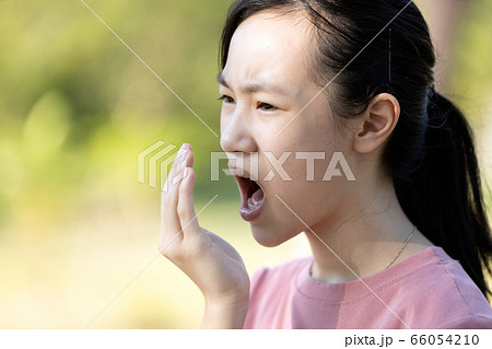 Asian child girl checking breath with her hand,woman have bad breath,bad smell,feel stinks,foul mouth from inside the mouth,tongue and tooth decay,oral health problems,halitosis,health care concept 66054210