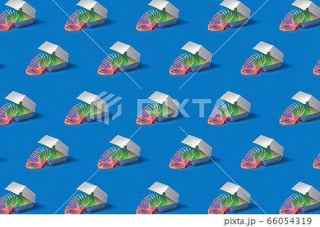 Flexible rainbow spring in a silver food container. 66054319