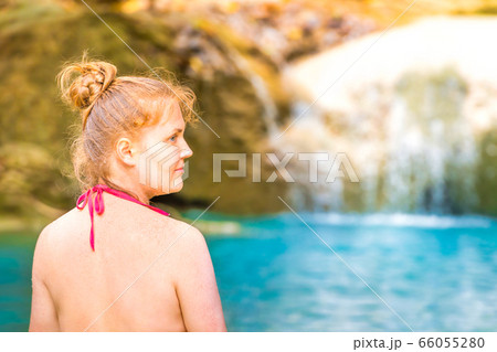 Rear view of young woman sitting at emerald blue 66055280