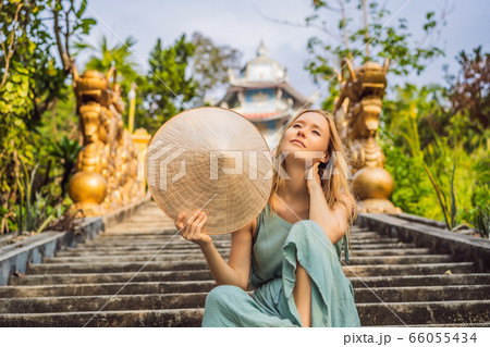 Young woman tourist in a traditional Vietnamese hat travels to Vietnam 66055434
