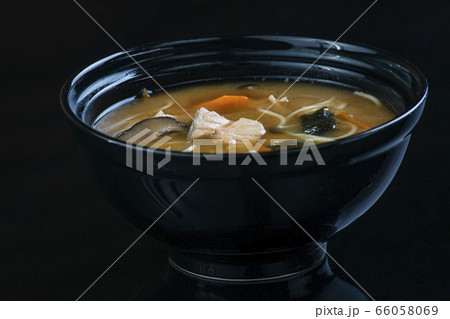 Japanese Soup With Chicken, Egg, Simeji Mushrooms and Eggplant On a Dark Background in a black plate. close up Japanese Soup With Chicken, Egg, Simeji Mushrooms and Eggplant On a Dark Background in a black plate. close up 66058069